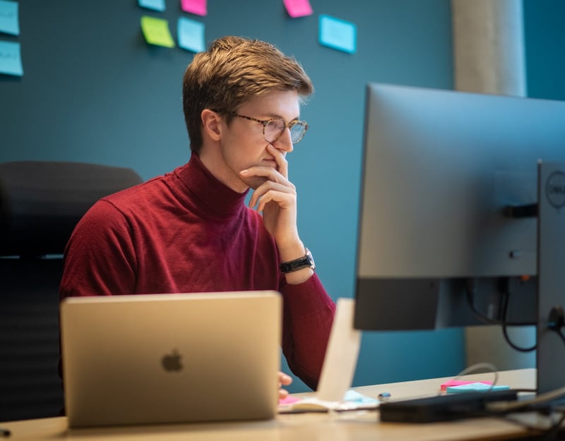 A man is working attentively in front of a PC.